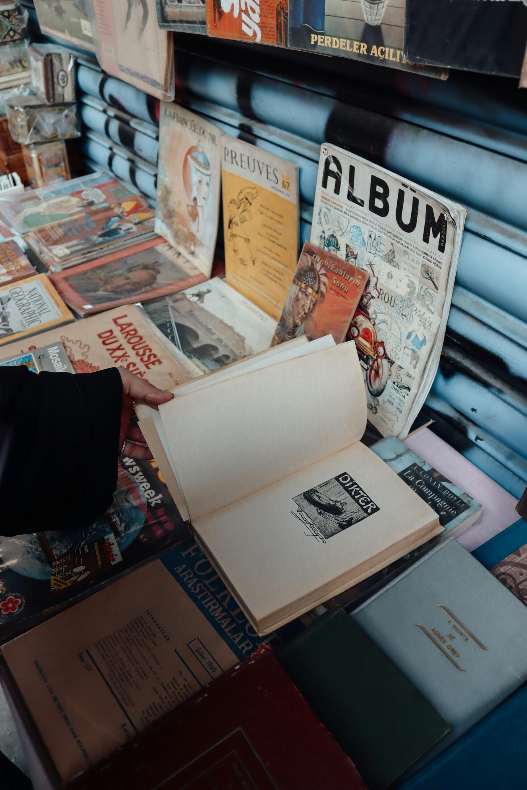 A collection of vintage books displayed at an outdoor market, showcasing antique editions.